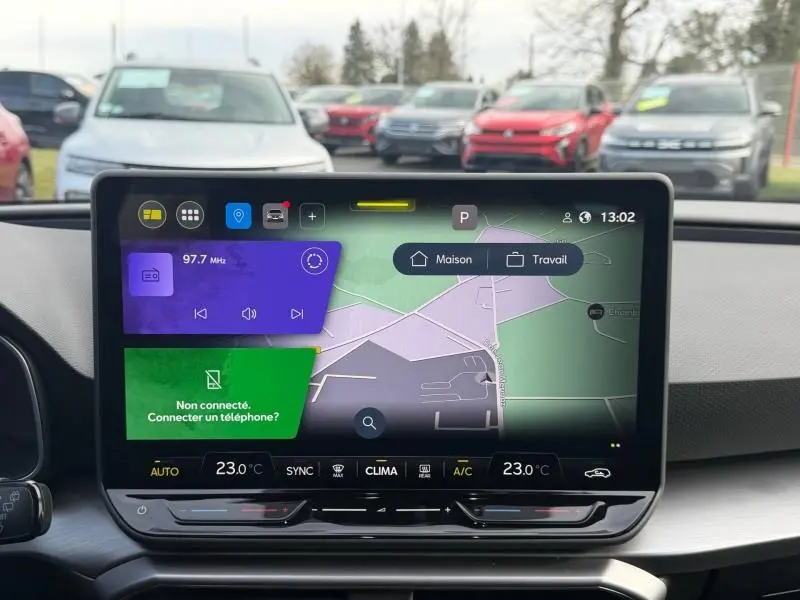 Écran tactile central du tableau de bord du SEAT LEON ST 2025, affichant navigation et réglages climatisation.