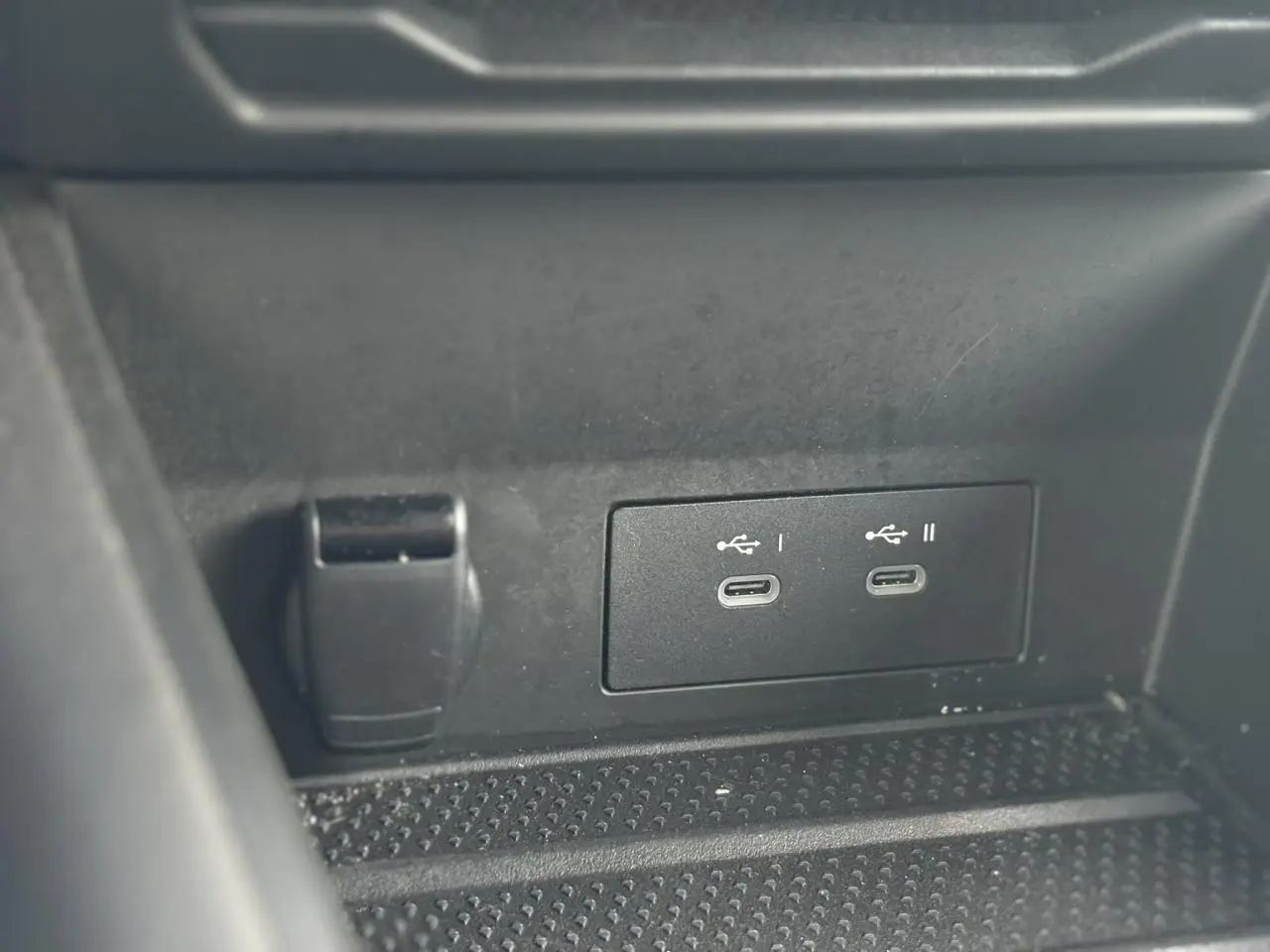 Détail des ports USB-C doubles et prise 12V dans la console centrale noire du Renault Symbioz Bleu Iron.