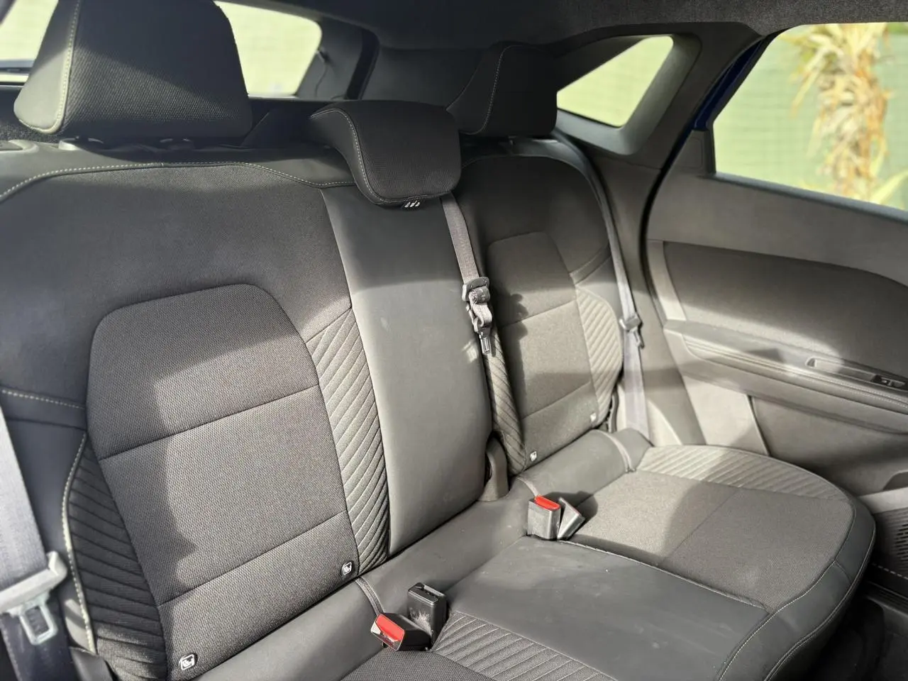 Vue intérieure de la banquette arrière noire du Renault SYMBIOZ 2025, avec ceintures de sécurité visibles.