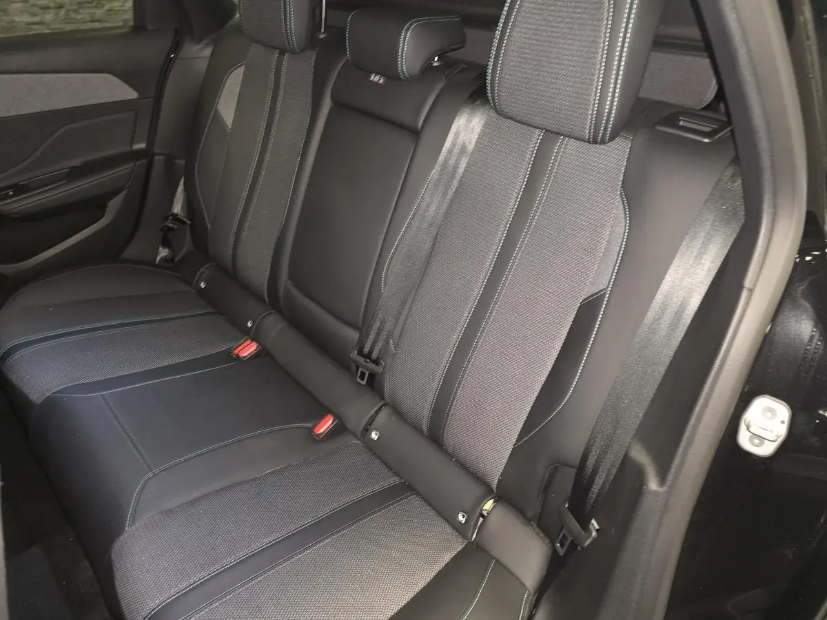 Vue latérale droite de la banquette arrière noire et tissu gris avec surpiqûres bleues du Peugeot 308 SW 2024.