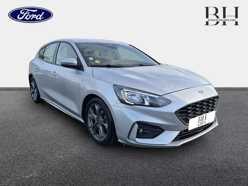 Ford Focus 1.5 EcoBlue 120ch ST-Line Business gris lunaire métallisé vue 3/4 avant avec jantes alu et calandre noire.