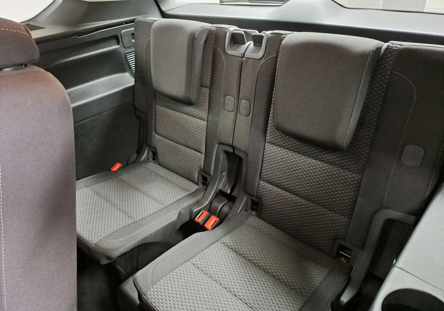 Vue intérieure sur la troisième rangée de sièges en tissu gris du Volkswagen Touran 2025, version 7 places.