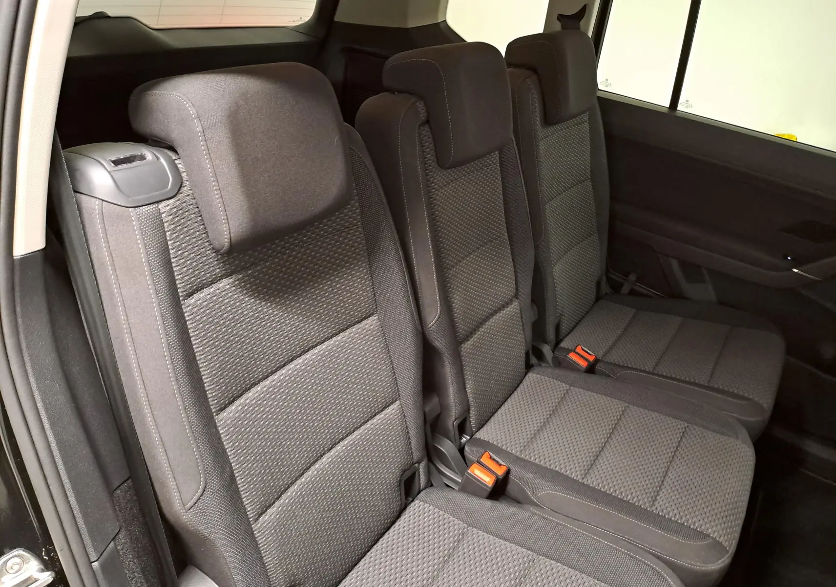 Vue intérieure montrant les trois sièges arrière gris foncé du Volkswagen Touran 2025, version 7 places.