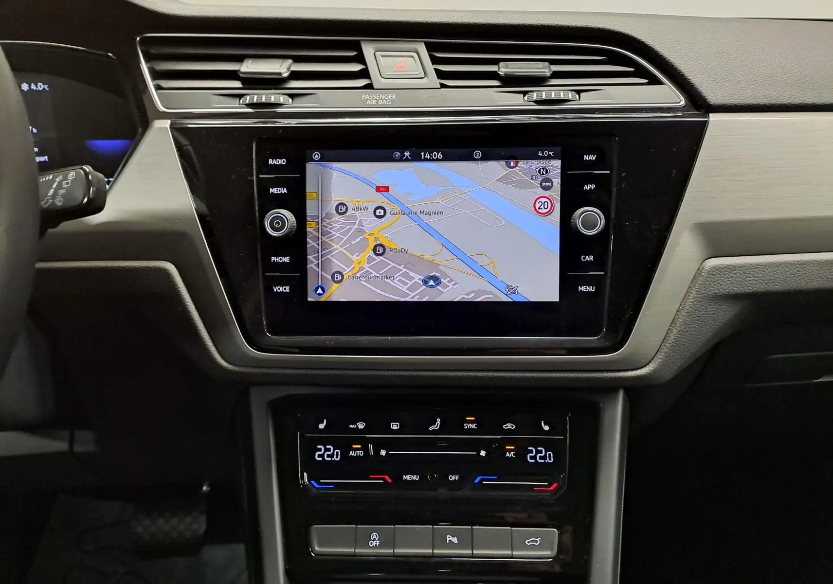 Vue rapprochée du tableau de bord du Volkswagen Touran 2025, écran tactile avec navigation et commandes climatisation digitales.