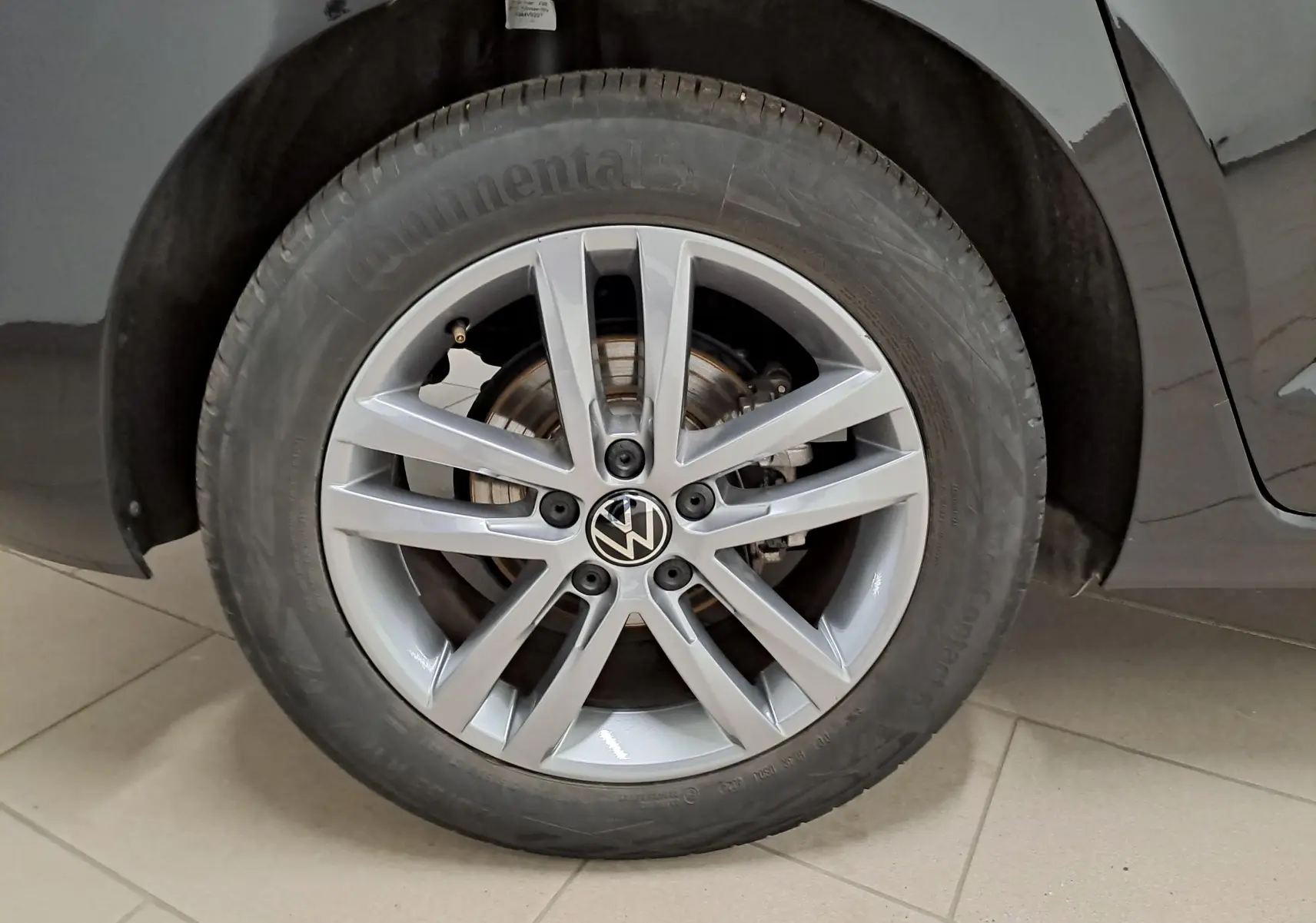 Gros plan sur la roue avant droite du Volkswagen Touran 2025 noir intense nacré avec jante alliage 7 branches.