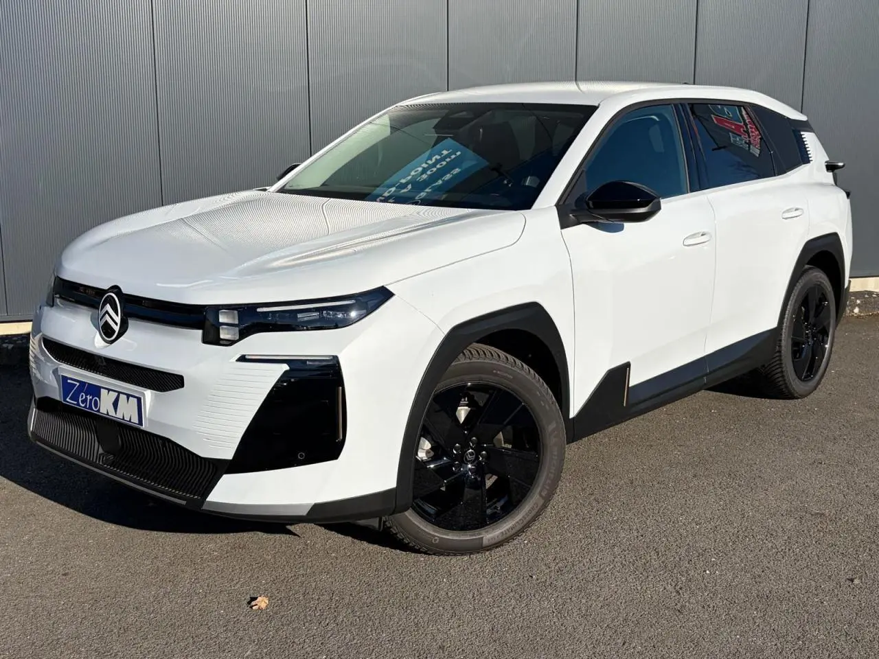Vue 3/4 avant d'un Citroën C5 Aircross blanc Okenite avec jantes noires et détails noirs contrastants.