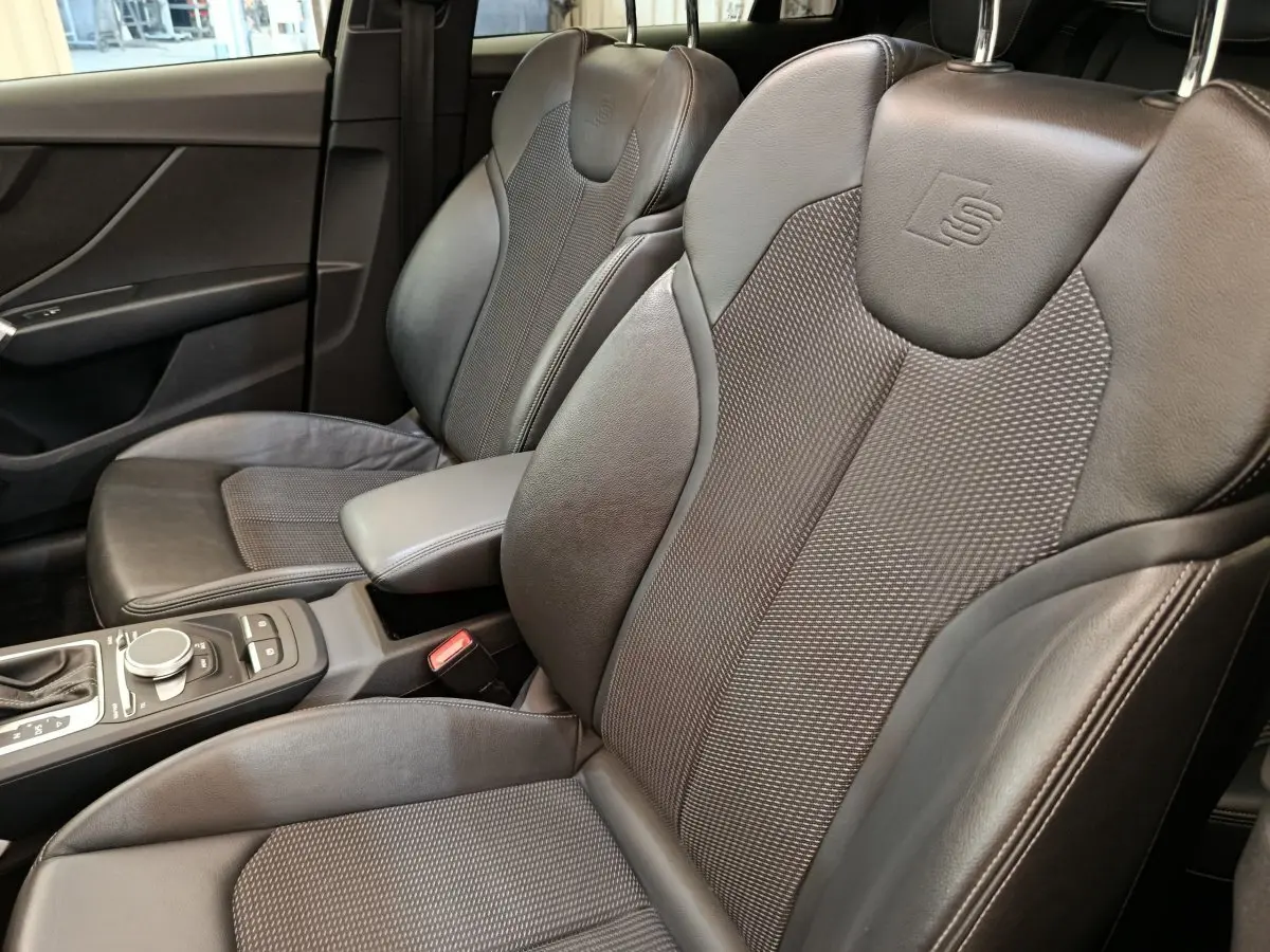 Vue rapprochée des sièges avant en cuir noir avec logo S embossé dans l’Audi Q2 35 TFSI S Line 2021.