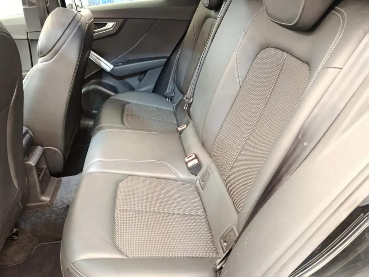 Vue latérale intérieure montrant la banquette arrière noire en cuir de l'Audi Q2 35 TFSI S Line 2021.
