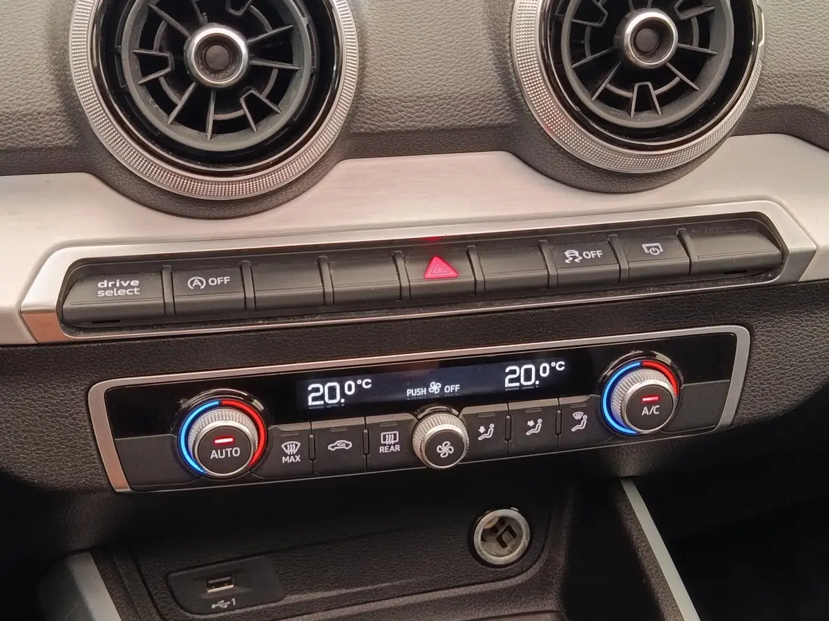 Détail de la console centrale de l’Audi Q2 noir 2021, montrant la climatisation digitale bi-zone à 20°C.