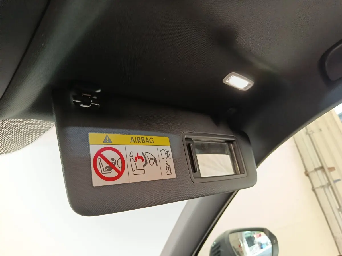 Détail du pare-soleil côté conducteur avec miroir et avertissement airbag dans l'Audi Q2 noir 2021.