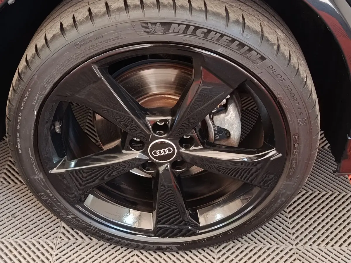 Gros plan sur la jante noire brillante Audi à 5 branches du SUV Q2 35 TFSI S Line, pneu Michelin visible.