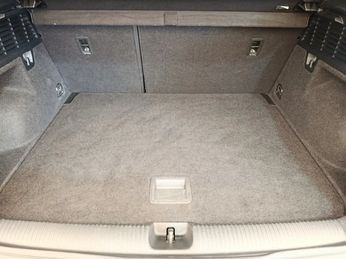 Vue intérieure du coffre spacieux et tapissé de gris de l'Audi Q2 35 TFSI S Line noir, avec banquette rabattable 2/3-1/3.