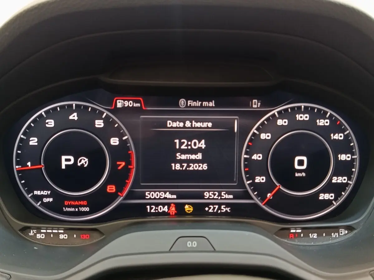 Vue rapprochée du tableau de bord numérique de l'Audi Q2 noir, affichant la vitesse, le compte-tours et la date.
