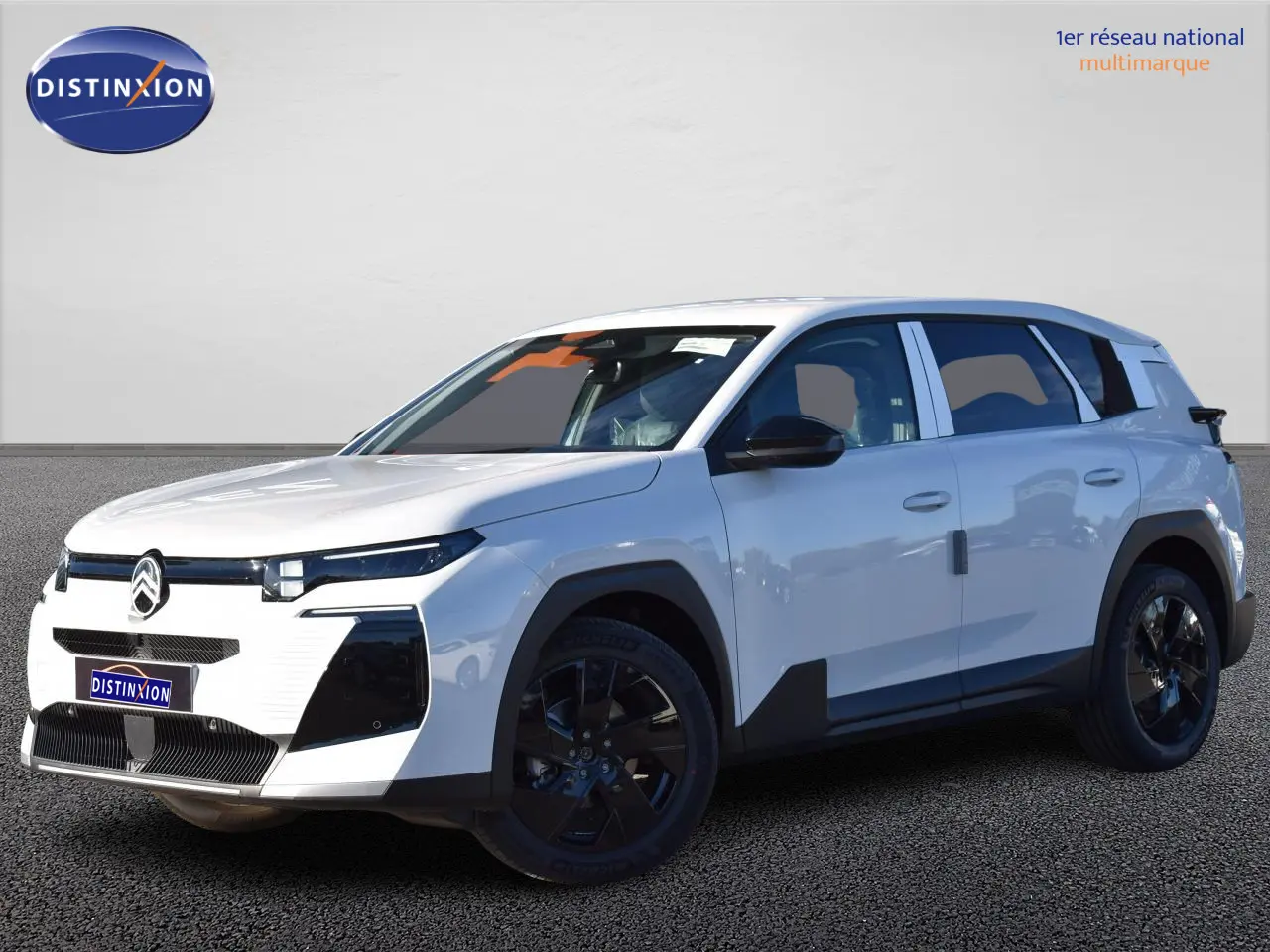 Vue 3/4 avant d'un Citroën C5 Aircross hybride blanc avec jantes noires et détails noirs contrastants.