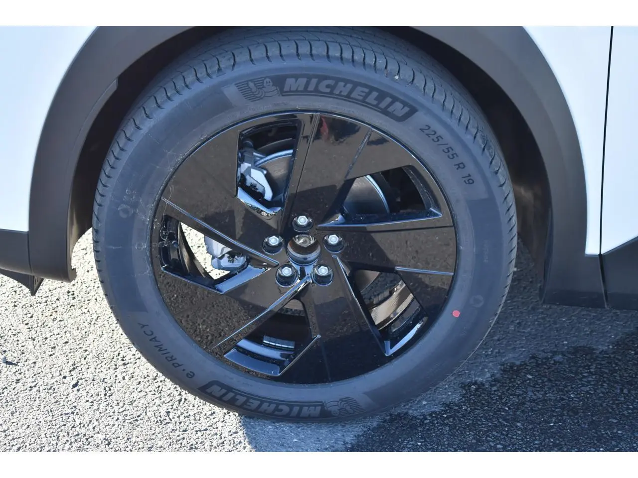 Gros plan sur la roue avant droite du Citroën C5 Aircross blanc avec jante alliage noire brillante 19 pouces.
