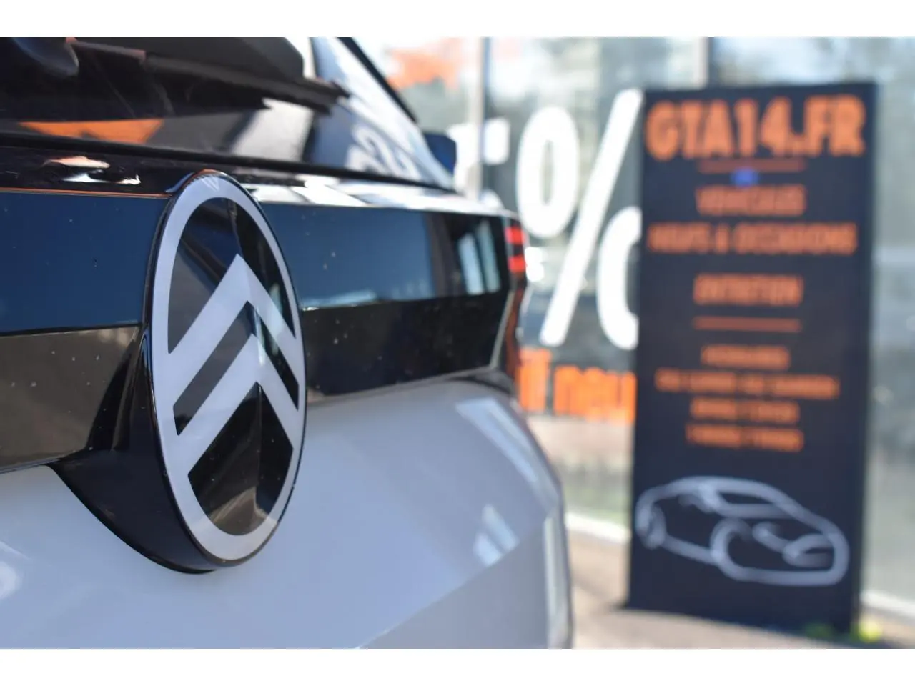Gros plan sur l'arrière blanc d'un Citroën C5 Aircross hybride avec logo Citroën brillant noir et chrome.