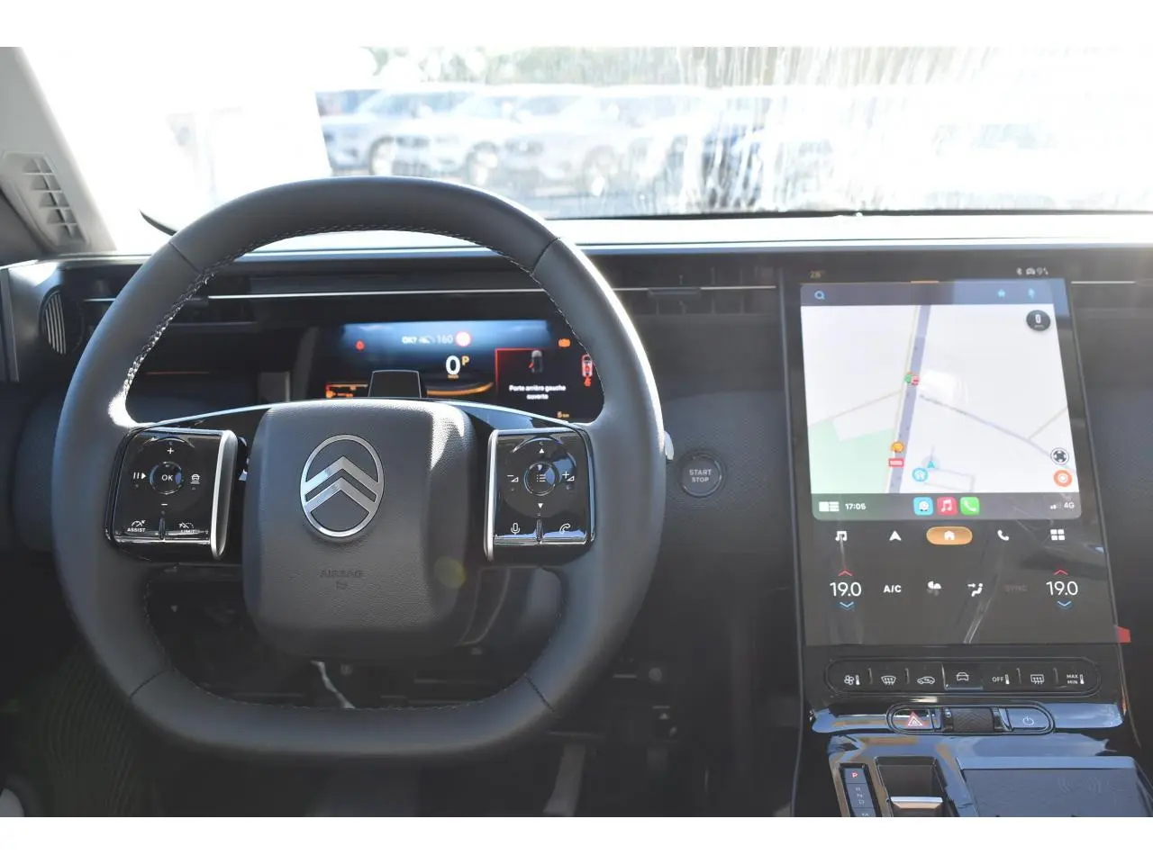 Vue intérieure centrée sur le volant multifonctions et l'écran tactile vertical du Citroën C5 Aircross blanc.