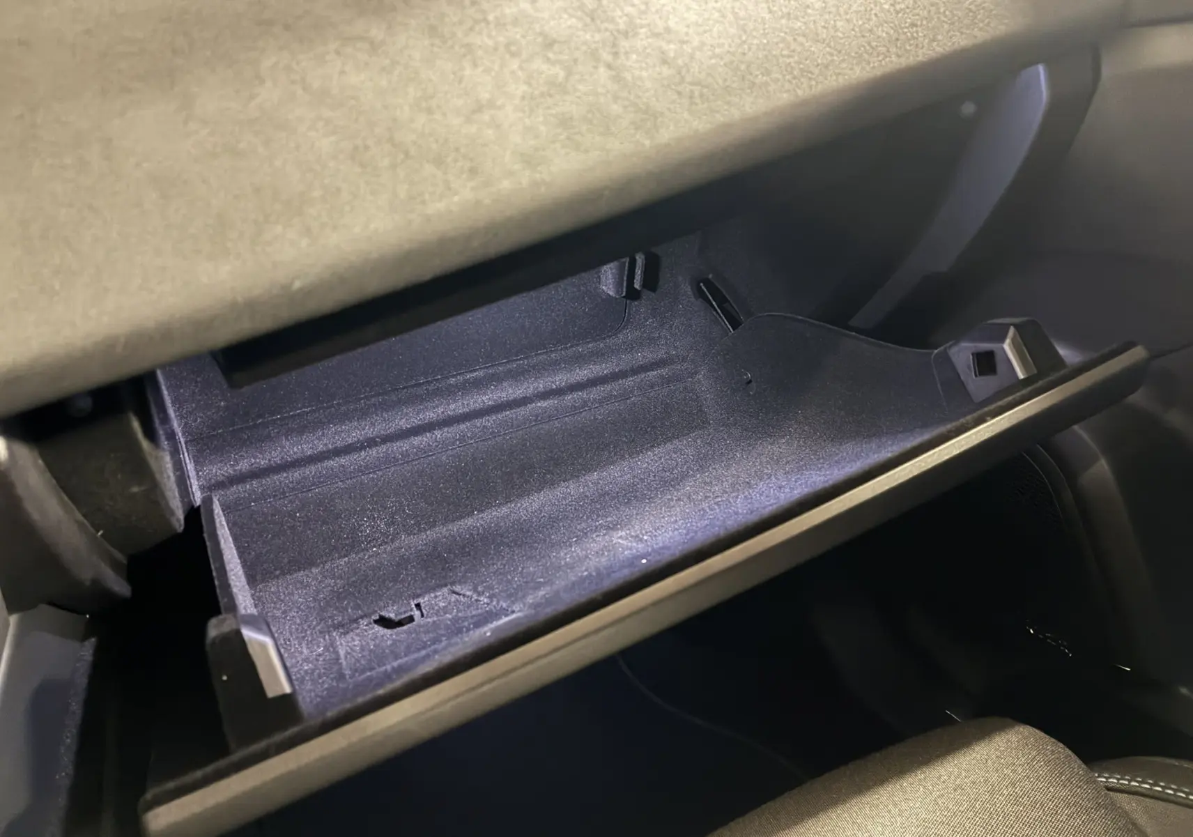 Gant de rangement ouvert côté passager du Lynk & Co 01 hybride rechargeable 2023 avec intérieur noir et bleu.