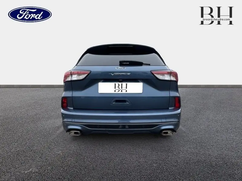 Vue arrière d'un Ford Kuga Vignale bleu azur métallisé avec double sortie d'échappement et toit panoramique visible.