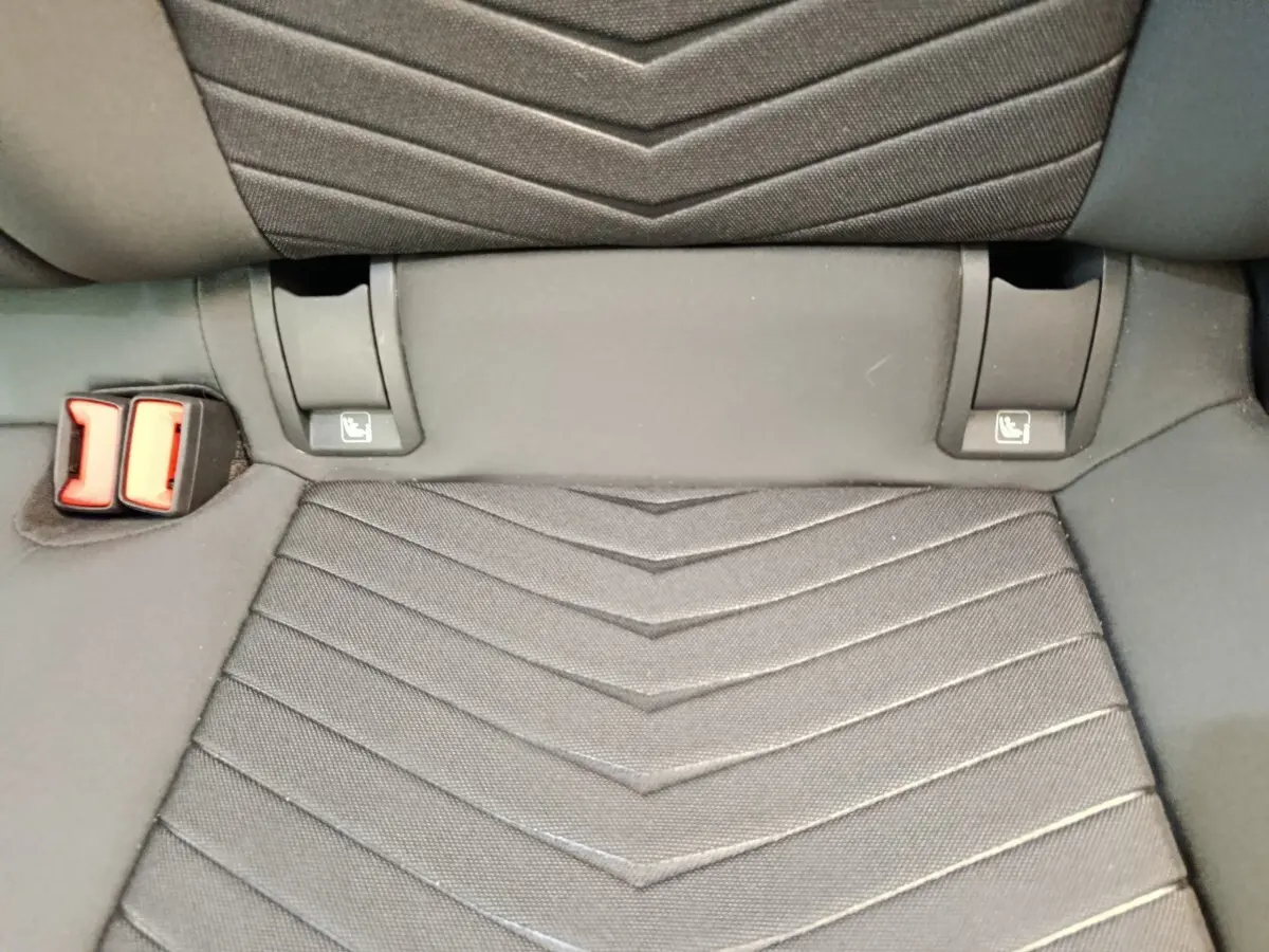 Détail de la banquette arrière grise foncée du CUPRA BORN 230ch avec attaches ISOFIX et boucle de ceinture rouge.