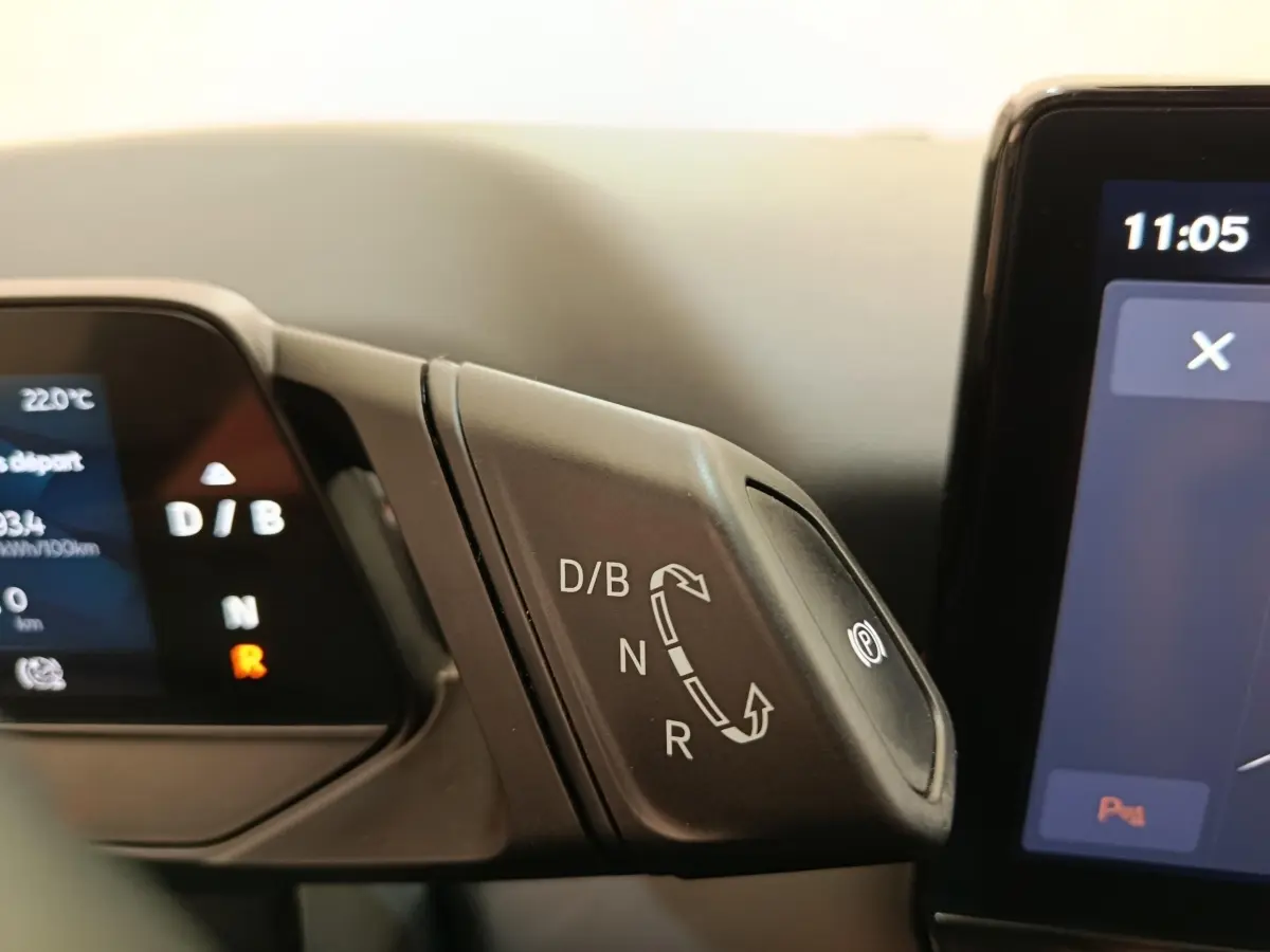 Gros plan sur la commande de boîte automatique électrique avec affichage digital du tableau de bord d'une CUPRA Born gris foncé.