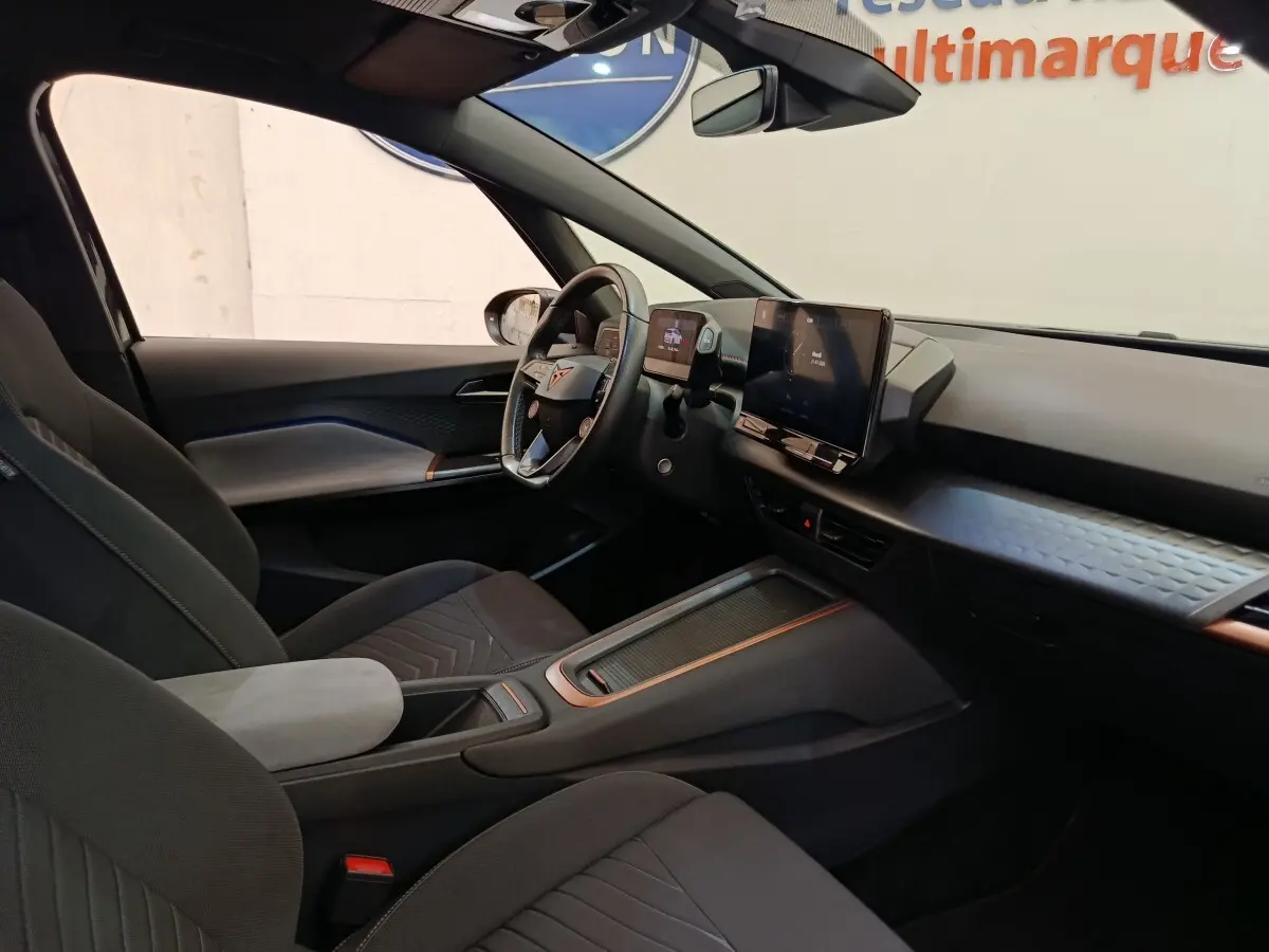 Vue intérieure côté conducteur de la CUPRA BORN 230ch gris foncé, avec tableau de bord digital et volant multifonctions cuir.