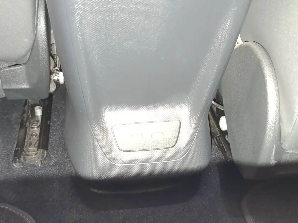 Vue rapprochée de la console centrale arrière noire et des sièges gris foncé du CUPRA Born 230ch électrique.