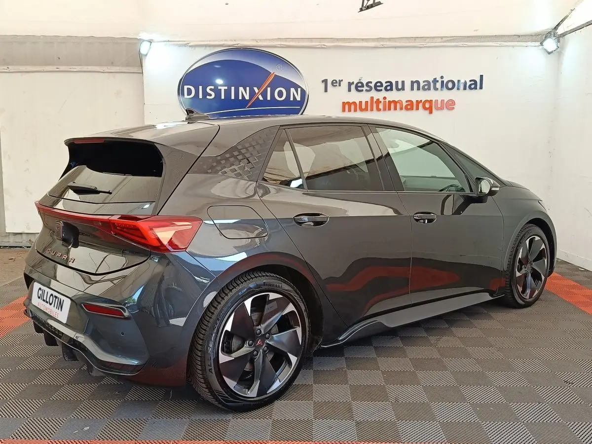 Vue 3/4 arrière droit d'une CUPRA BORN gris foncé électrique avec jantes noires et feux arrière LED distinctifs.