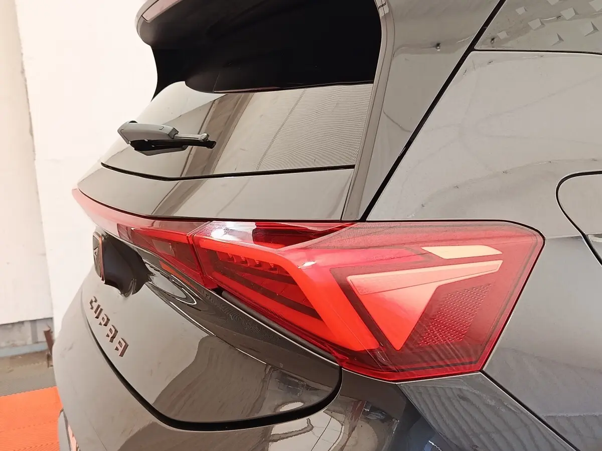 Vue arrière droite du CUPRA BORN gris foncé, mettant en valeur le feu arrière LED et le logo CUPRA sur le hayon.