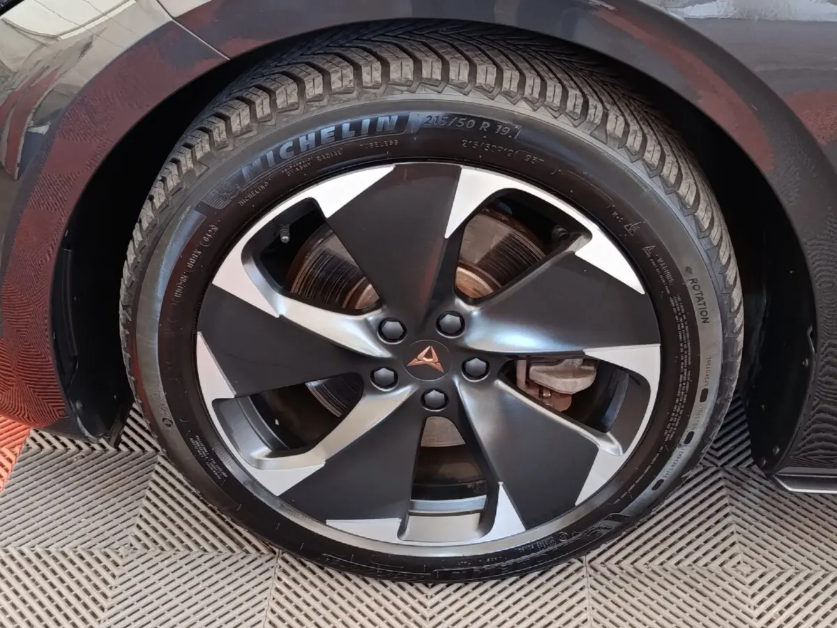 Gros plan sur la roue avant droite du CUPRA BORN gris foncé avec jante alliage bicolore et logo CUPRA central.