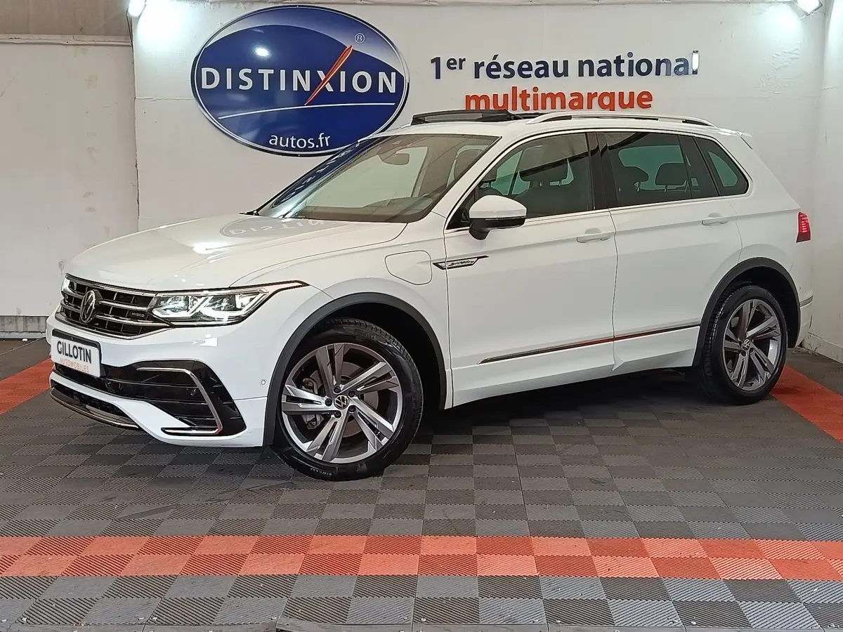 Volkswagen Tiguan blanc 2023 hybride rechargeable en 3/4 avant droit avec jantes alliage et toit ouvrant.