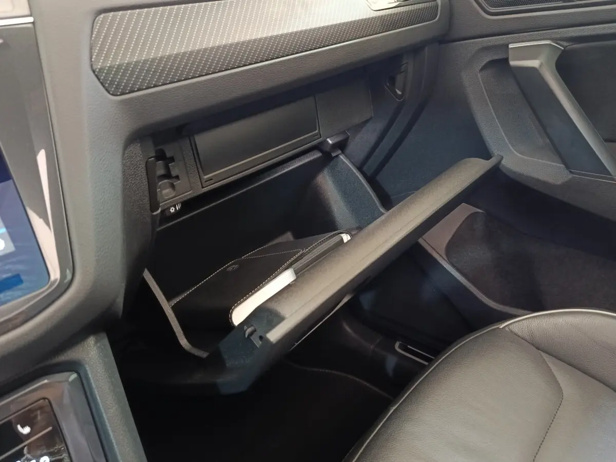 Intérieur du Volkswagen Tiguan 2023, vue sur la boîte à gants ouverte côté passager avec siège en cuir gris.