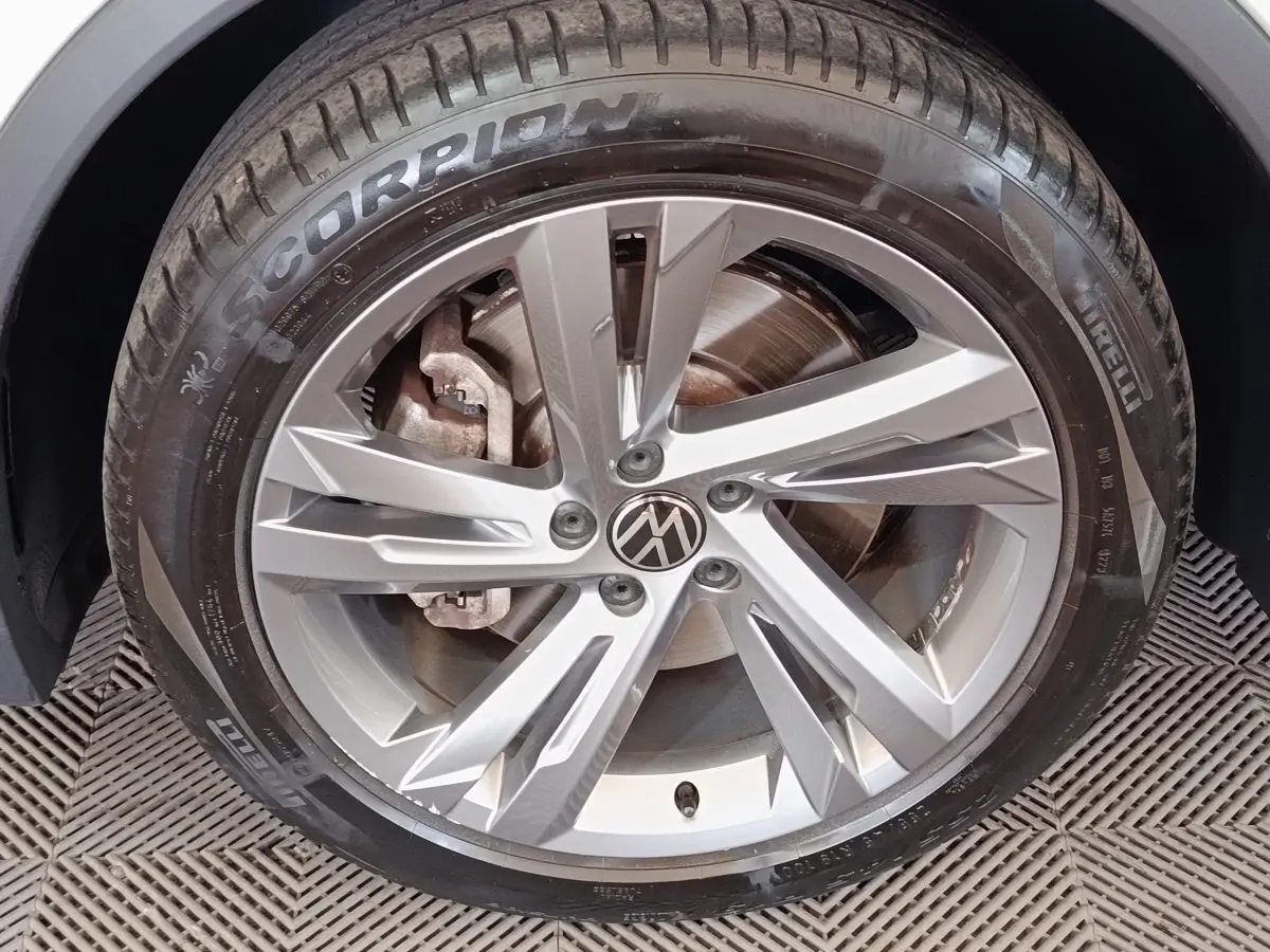 Gros plan sur la jante alliage argentée et pneu Pirelli Scorpion du Volkswagen Tiguan blanc hybride rechargeable 2023.