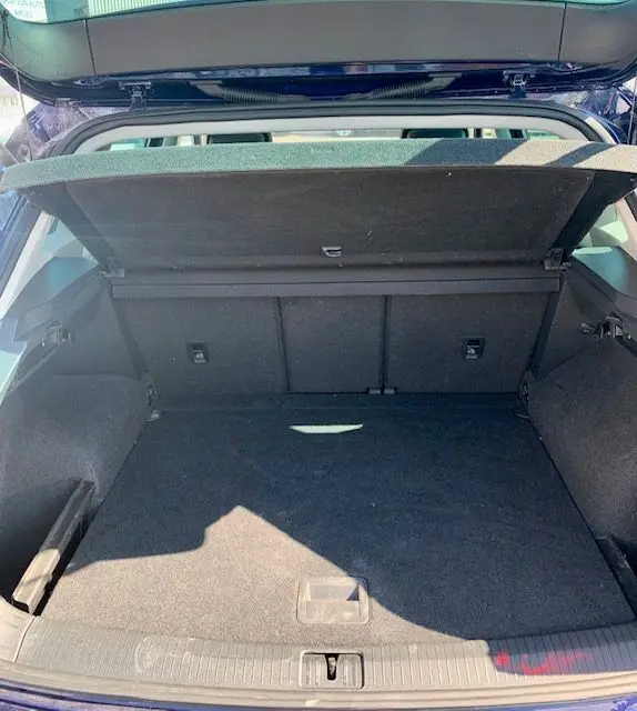 Coffre ouvert du Volkswagen Tiguan 2018 bleu, vue de l'arrière montrant un espace de chargement spacieux et propre.