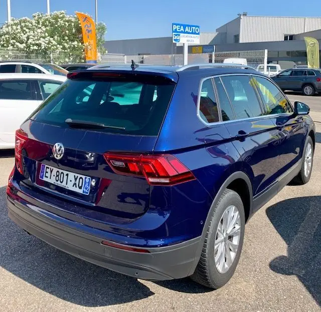 Volkswagen Tiguan bleu 3/4 arrière droit, version 2.0 TDI 150ch confortline business de 2018 en extérieur.