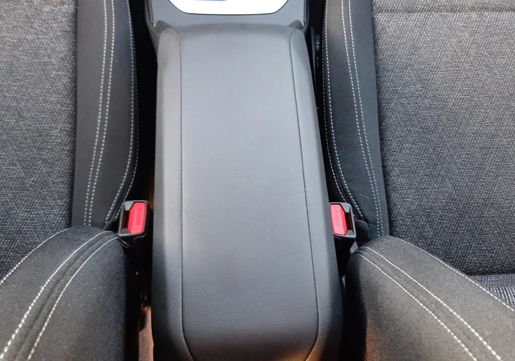 Vue plongeante sur la console centrale et les sièges tissu gris foncé de la BMW Série 1 F70 120D M Sport 2025.