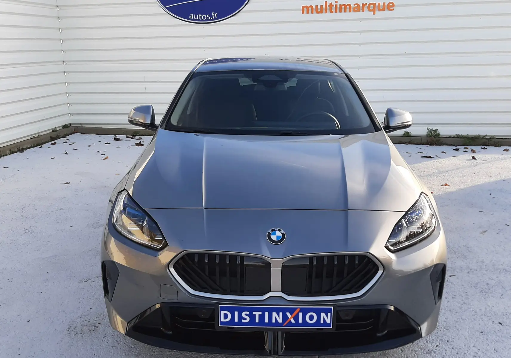 BMW Série 1 gris Skyscraper vue de face, mettant en valeur la calandre M Sport et les phares LED avancés.