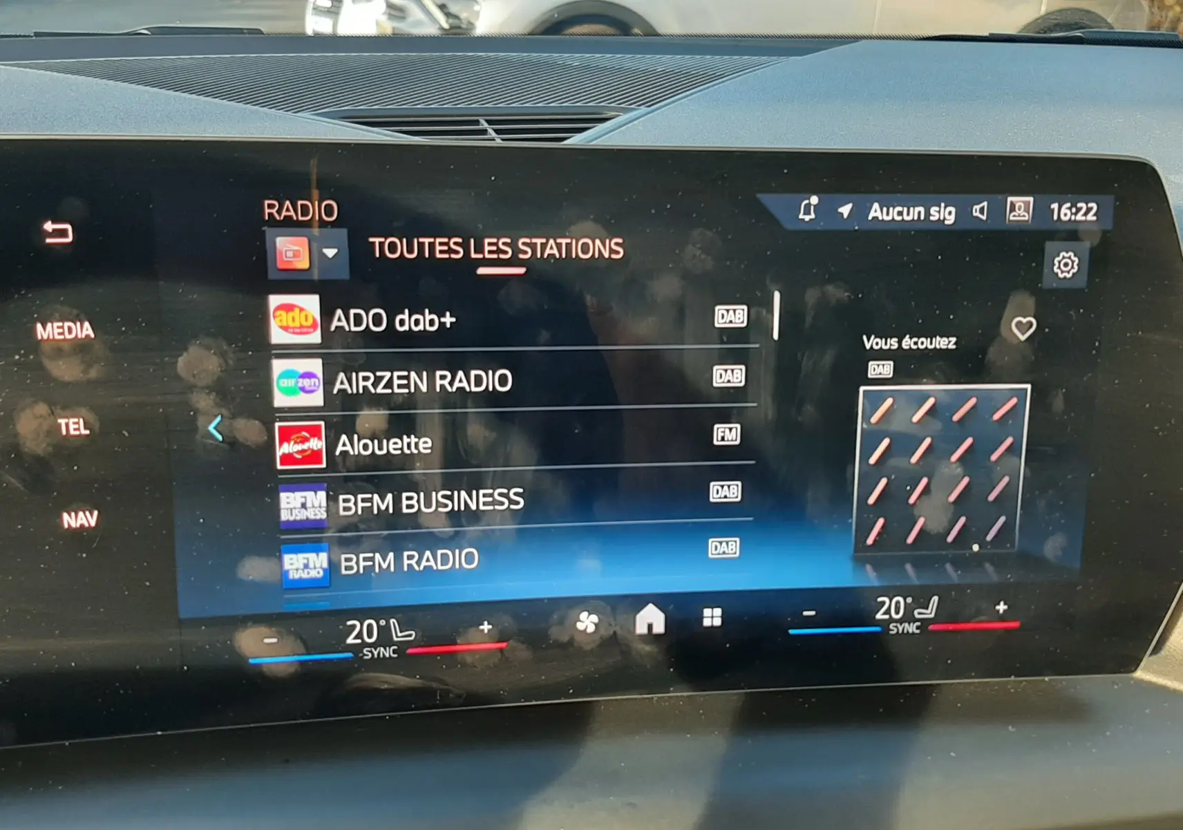 Vue intérieure du tableau de bord de la BMW Série 1 120D M Sport avec écran tactile radio et climatisation affichés.