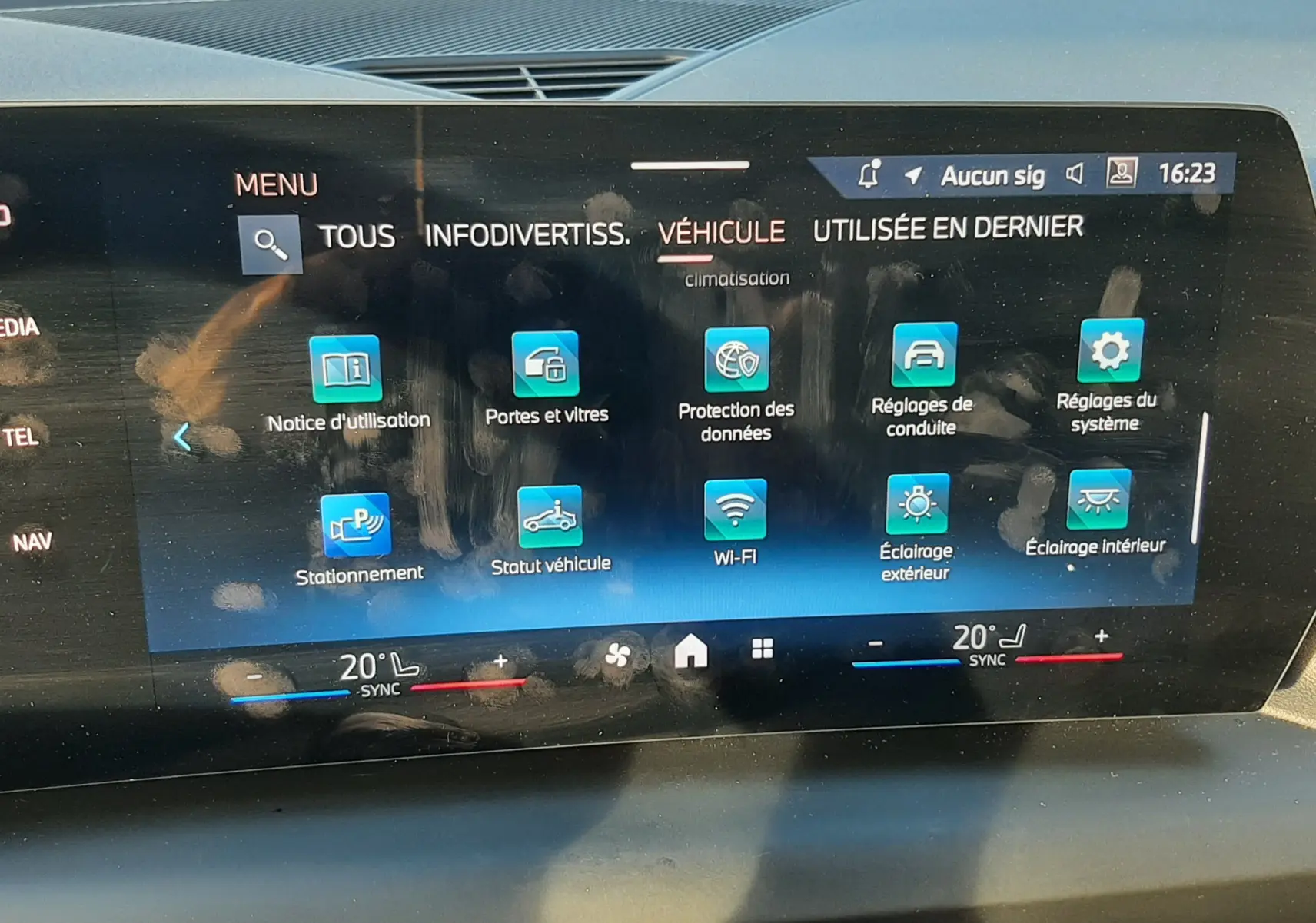 Écran tactile central de la BMW Série 1 2025 affichant le menu véhicule avec commandes climatisation et connectivité.