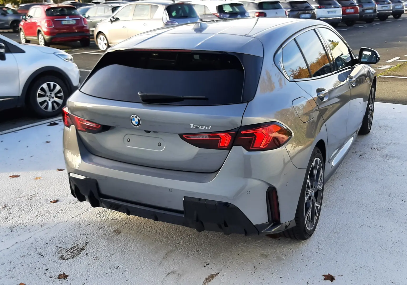 BMW Série 1 gris Skyscraper vue 3/4 arrière droit, avec feux LED et jantes alliage bicolores visibles