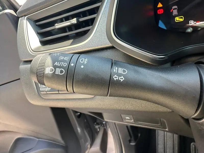 Gros plan sur la commande des phares et clignotants du tableau de bord gris foncé du Renault Captur 2025.