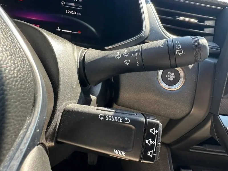 Gros plan intérieur sur les commandes au volant et bouton start/stop du Renault Captur gris Cassiopée métallisé/Noir Etoilé.