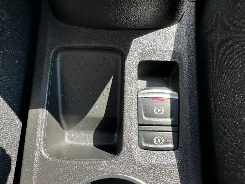 Gros plan sur la console centrale noire du Renault Captur 2025, avec bouton frein à main électrique et arrêt auto moteur.