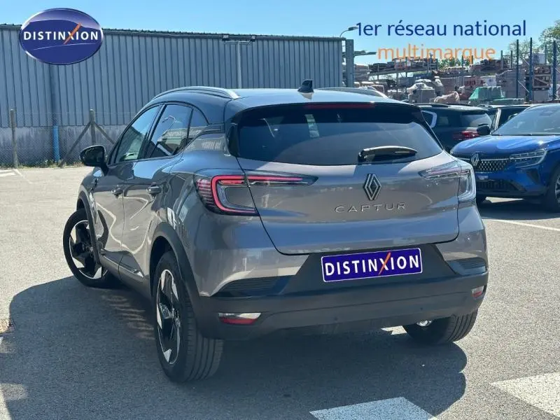 Vue 3/4 arrière du Renault Captur 2025 gris Cassiopée métallisé avec toit noir et feux arrière LED distinctifs.