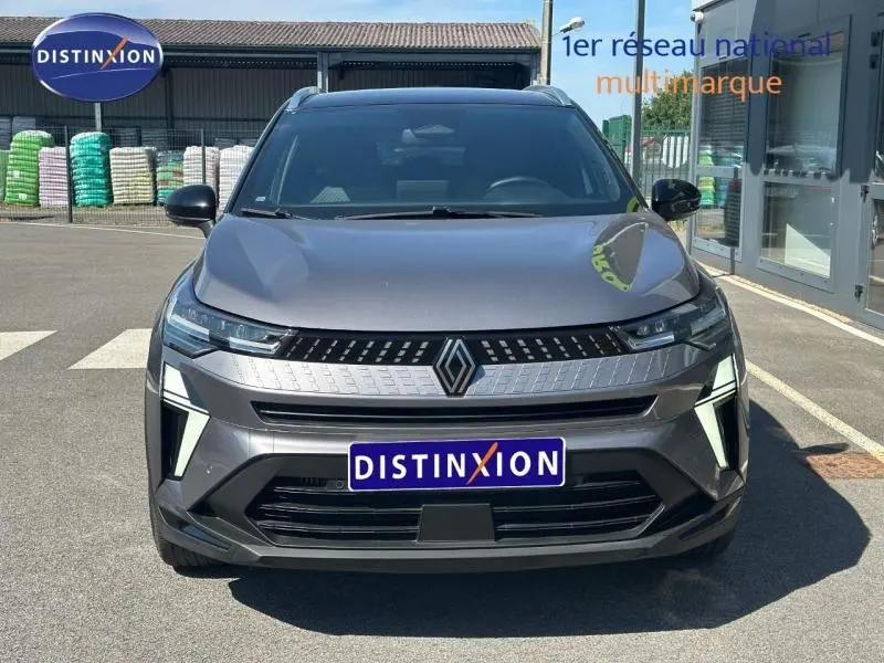 Vue de face du Renault Captur 1.0 Eco-G 100ch Techno 2025 en gris Cassiopée métallisé avec calandre et phares LED distinctifs.