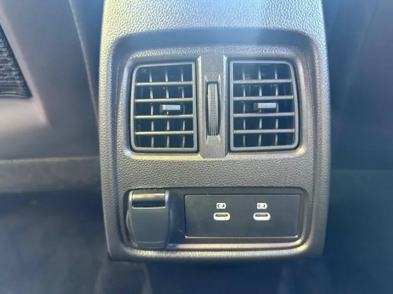 Vue rapprochée des bouches d’aération arrière et ports USB-C noirs du Renault Captur gris Cassiopée métallisé.