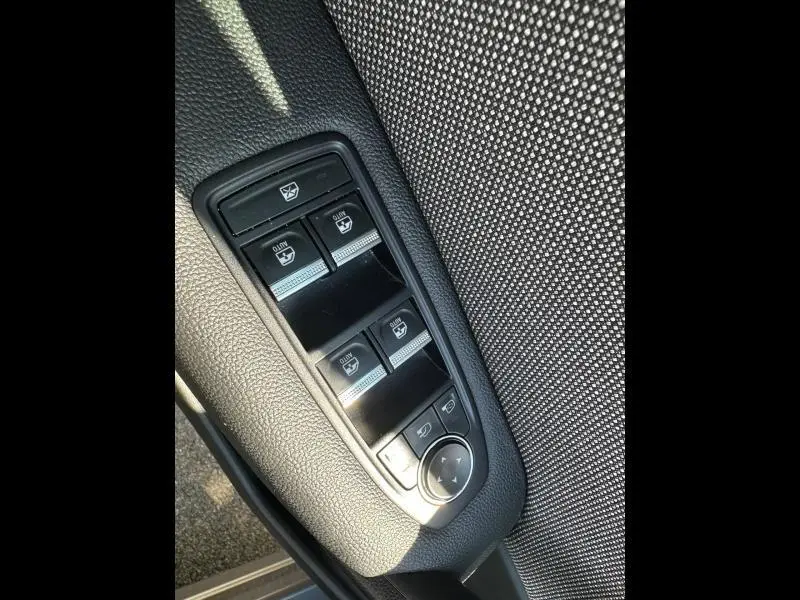 Gros plan sur les commandes de lève-vitres et rétroviseurs côté conducteur du Renault Captur gris Cassiopée métallisé.