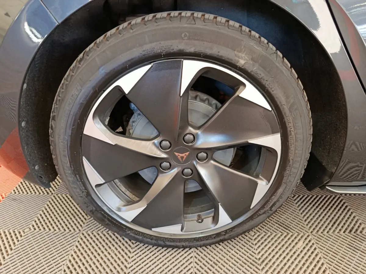 Gros plan sur la roue avant gauche de la CUPRA BORN gris foncé, mettant en valeur la jante bi-ton au design moderne.