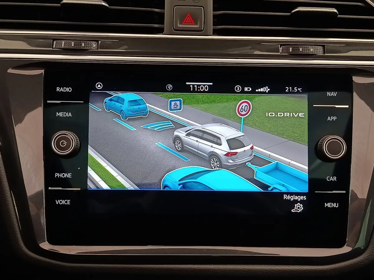 Écran tactile du tableau de bord montrant l’aide au stationnement avec représentation graphique d’un SUV gris en vue arrière.
