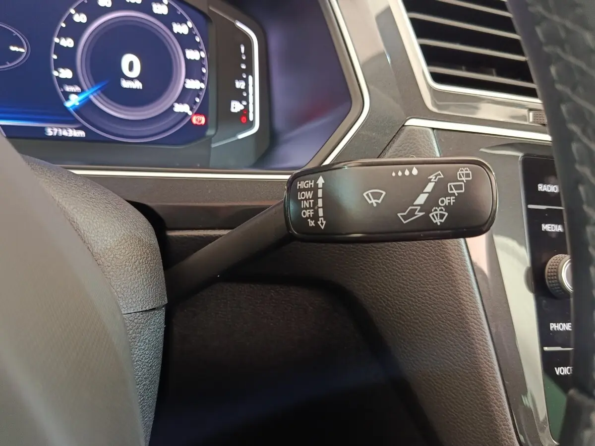 Gros plan sur la commande des essuie-glaces du Volkswagen Tiguan 2.0 TDI 150 DSG7 Elegance, intérieur noir.